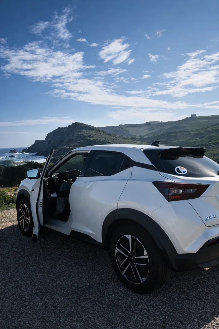 Coche de alquiler blanco frente a la costa de Menorca